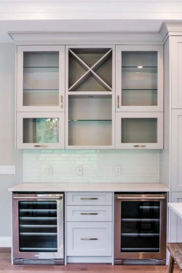 The Piva family loves to entertain, and with a large extended family, having a separate bar area between the kitchen and living room made mixing drinks a breeze. The glass doors were chosen for the upper cabinets so the families beautiful collection of crystal could be on display.